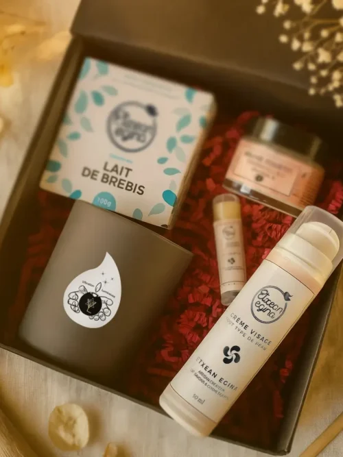 Coffret “Abondance” – Vibration Lumineuse. Ensemble bien-être haut de gamme composé d’un savon au lait de brebis, d’un stick à lèvres, d’une crème visage, d’un baume fouetté au monoï et d’une bougie de la gamme Élégance, fabriquée artisanalement dans le Lot-et-Garonne.